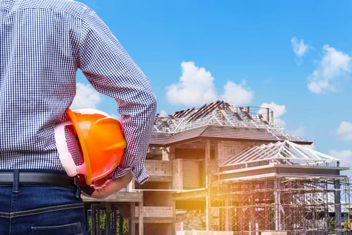 engineer-holding-safety-hat-at-new-home-construction