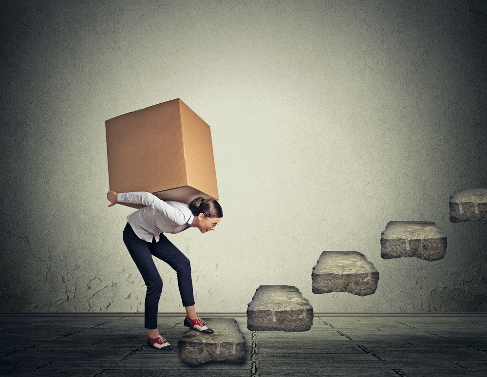 woman-carrying-large-heavy-box-on-her-back-upstairs