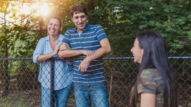 neighbors smiling near fence