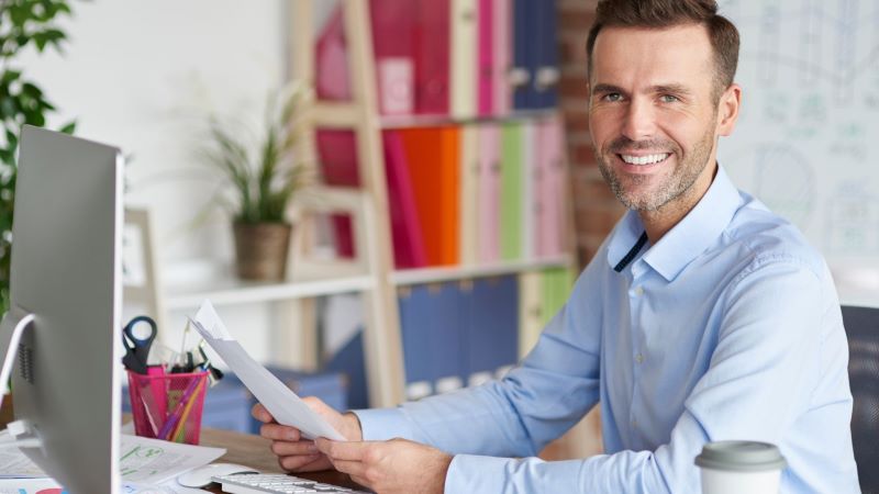 smiling business man sitting at desk